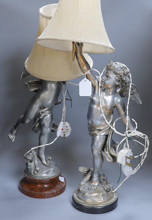 A pair of silvered metal cherub lamps in dancing pose bearing torch lamp, signed L. Gregoire